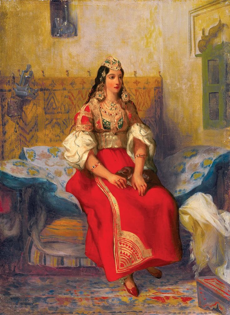 Une femme portant un habit traditionnel algérien avec plein de broderie et de couleur rouge